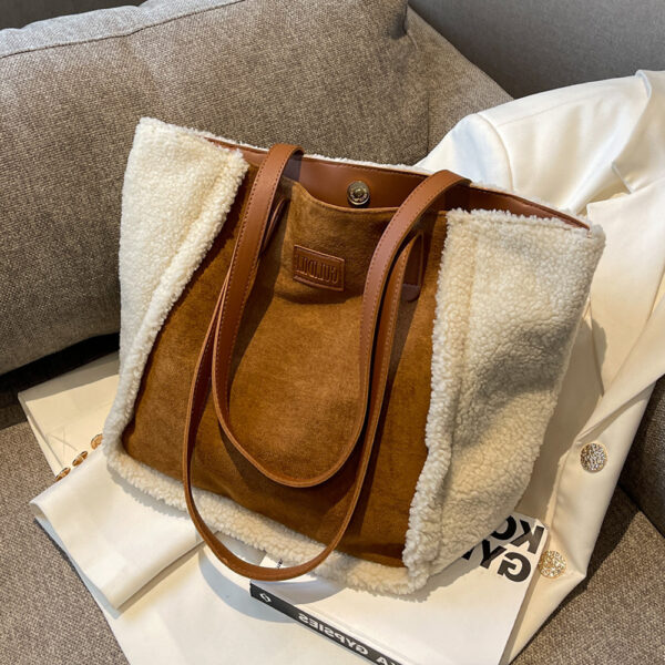 Bolso shopper marrón con lana blanca sobre un libro y una chaqueta blanca en un sofá gris